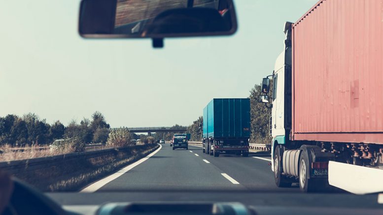 Image of semi trucks looking through car windshield