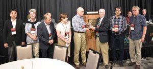 Flanked by colleagues, Mike Havey receives a lifetime recognition award from NOA Executive Vice President Greg Yielding.
