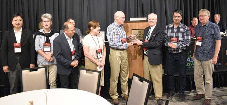 Flanked by colleagues, Mike Havey receives a lifetime recognition award from NOA Executive Vice President Greg Yielding.