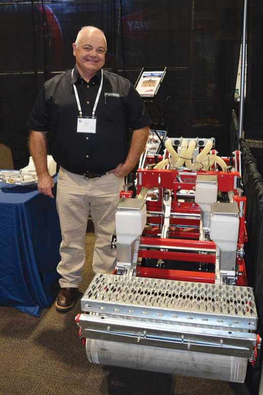 Brad Bonny shows off an onion planter in the Gearmore booth.